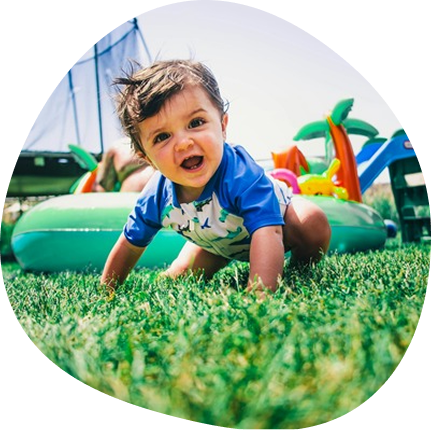 Toddler enjoying Adventure Camp 2026 at Playful Scholars in Midland, MI, featuring water play and fun activities.