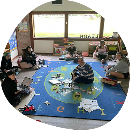 Educators collaborating in a warm preschool setting at Playful Scholars in Midland, MI.