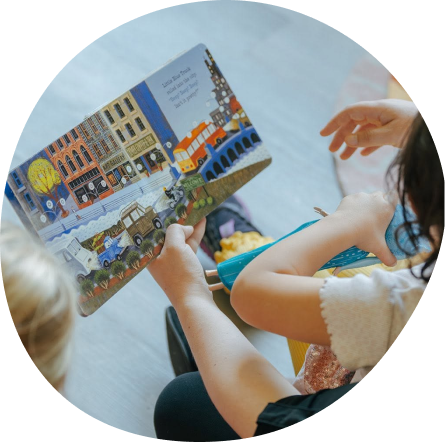 Children reading a book at Midland's Playful Scholars preschool, fostering curiosity and community.