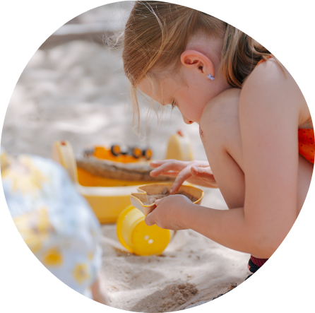 Child engaged in creative play with sand at Playful Scholars, Midland MI