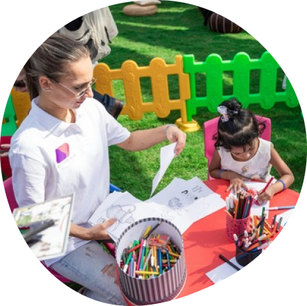 Child and teacher drawing together in a creative learning environment at Playful Scholars in Midland, MI.