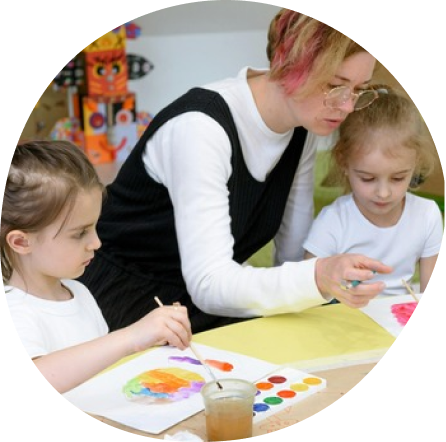 Teacher guiding children in colorful art activity at Playful Scholars in Midland, MI, fostering creativity and growth.