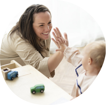 Caregiver interacts warmly with infant at Playful Scholars in Midland, MI, fostering gentle learning and safety.