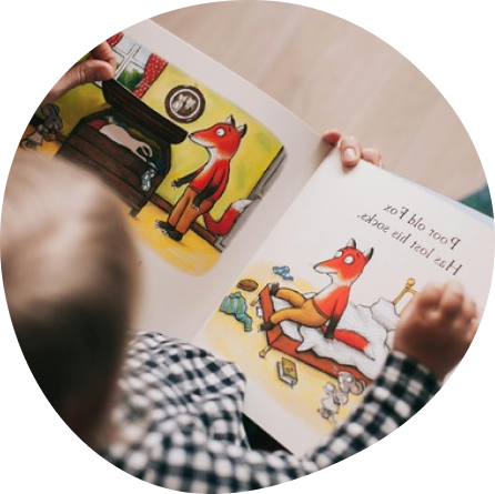 Preschooler enjoying a storybook at Playful Scholars daycare in Midland, MI, where creative play sparks joyful learning.