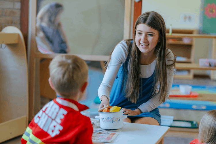 Teacher engaging with children at Playful Scholars preschool in Midland, MI, fostering curiosity and friendships.