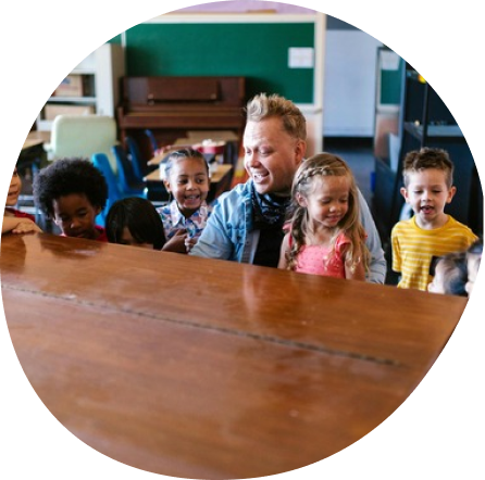 Children learning and playing at Playful Scholars Pre-K in Midland MI with a teacher, fostering creativity and confidence.
