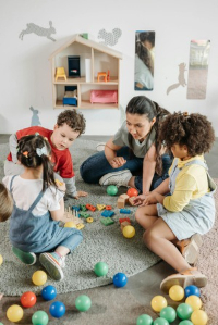 Children and teacher engaged in activities at Playful Scholars preschool in Midland, MI, promoting curiosity and community.