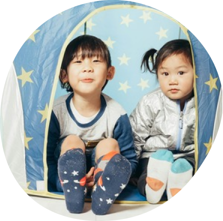 Two preschoolers playing creatively in a tent at Playful Scholars daycare in Midland, MI.