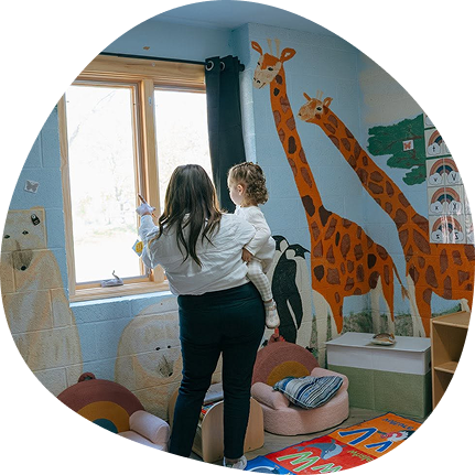 Teacher and child at Playful Scholars Midland in a colorful, nurturing preschool environment.